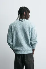 Cárdigan de punto con mezcla de algodón, de corte relajado y cuello en pico. Presenta un diseño con efecto de roturas y acabado jaspeado en tonos azul y blanco, con cierre frontal de botones y puños y bajo en rib.