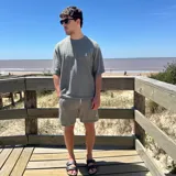 Remera negra tejida con cuello redondo y manga corta, con logo bordado en el pecho.