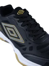 Championes Umbro Grip Pad para hombre, diseñados para deportes de cancha como pádel. Presentan un diseño en color negro con detalles en dorado, entresuela blanca y suela de goma color caramelo para mayor tracción.
