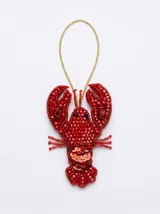 Llavero o charm decorativo en forma de langosta, confeccionado artesanalmente con una combinación de cristales, abalorios y lentejuelas en color rojo intenso, con cordón dorado para colgar.