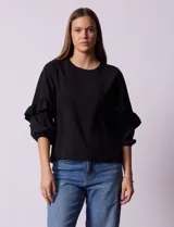 Blusa de gasa estampada con flores azules y violetas sobre fondo blanco, de manga 3/4 con volados.