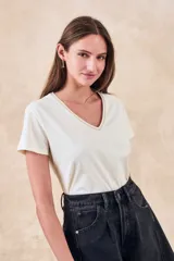 Remera de algodón color mostaza, de manga corta y escote en V con detalle metalizado.