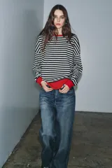 Jersey de lana 100% con estampado de rayas horizontales blancas y negras, cuello redondo y manga larga.