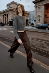 Pantalón de tiro alto con pernera recta, confeccionado en tejido de textura sutil. Cuenta con cierre frontal de cremallera, botón interior y gancho, bolsillos laterales y falsos bolsillos traseros de vivo. Incluye un cinturón fino a juego con hebilla metálica.