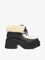 Bota de cuero negro con plataforma robusta y taco medio. Presenta detalles de piel de oveja en el borde superior y la lengüeta, con sistema de ajuste mediante cordones negros.