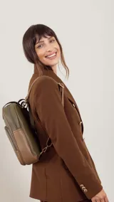 Mochila color bordó con doble asa superior, correas traseras regulables y bolsillo frontal con cierre. Se puede usar como mochila o como cartera.