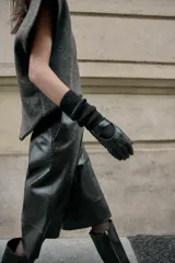 Guantes largos combinados con efecto piel y tejido de punto acanalado de lana. Presentan un diseño con abertura en el dorso y detalle de botón a presión.