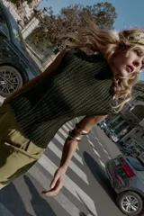 Top de punto acanalado color verde militar, con cuello alto y sin mangas.