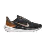 Championes de running Nike Air Winflo 9, color gris oscuro con detalles en cobre y plateado. Presentan diseño aerodinámico con logo lateral metalizado, entresuela blanca amortiguada y suela con relieve para mayor tracción.