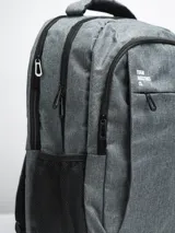 Mochila gris con cierre superior y bolsillo frontal con cierre. Tiene dos bolsillos laterales de red y logo de la marca en blanco en la parte superior.