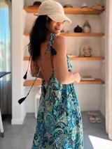 Vestido largo de seda india con estampado paisley en tonos azul, verde y beige. Tiene escote en V pronunciado, espalda descubierta y tirantes finos con borlas decorativas.