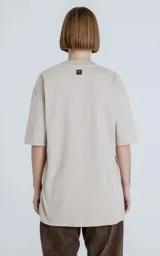 Remera de algodón premium color beige, corte extra oversize con hombros caídos y cuello redondo rib al tono.
