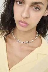 Collar de cadena con cuentas metálicas plateadas, cristales facetados de colores y dijes en forma de estrella.