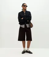 Campera de punto de corte regular y estilo oversized, confeccionada en una mezcla de viscosa, poliéster y poliamida. Presenta cierre frontal completo, mangas largas con puños acanalados y acabado acanalado en el ruedo.