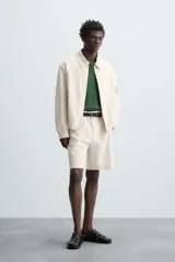 Cazadora de hombre color beige claro, de corte relajado, con cuello solapa, cierre frontal de cremallera y puños y bajo elásticos. Presenta una textura de rayas sutiles y efecto lavado.