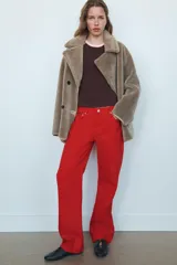 Abrigo reversible de corte recto con cuello solapa, manga larga y cierre frontal de doble botonadura. Presenta un diseño de efecto pelo en un lado y efecto piel en el reverso, con bolsillos de plastrón en el frente.