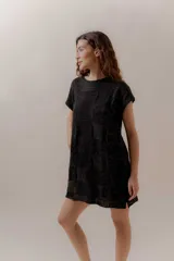 Vestido corto negro con diseño tejido en bloques, de mangas cortas y corte recto.