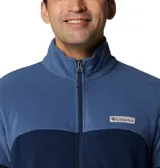 Polar Columbia de hombre, modelo Basin Trail III Full Zip, color azul marino con bloques de color azul más claro en hombros y parte superior del pecho. Presenta cuello alto, cierre frontal completo y bolsillos laterales con cierre.