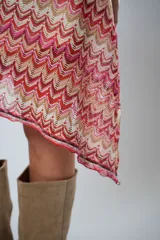 Minifalda asimétrica de crochet con diseño de ondas en tonos rojo, rosa y beige.