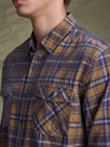 Camisa de pana color azul marino, con mangas largas, cuello clásico y dos bolsillos frontales con solapa y botón.