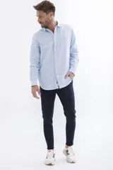 Camisa celeste a rayas verticales blancas, de manga larga y corte clásico.