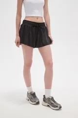 Short de poliéster color celeste, de calce holgado y tiro alto, con cintura elástica ajustable mediante cordón y bolsillos laterales.