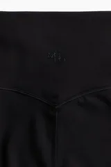 Leggings deportivos negros de tiro alto con cintura ancha y tejido funcional que ayuda a absorber el sudor.