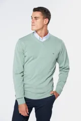 Suéter de tejido fino color azul marino, con cuello en V y manga larga. Presenta un pequeño logo bordado en el pecho.