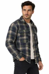 Sobrecamisa de franela a cuadros en tonos marrones, blancos y rojos, con mangas largas, bolsillos frontales con solapa y cierre de botones.