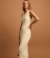 Vestido midi color crema, tejido en punto texturizado, sin mangas y con cuello redondo.