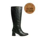 Bota de caña alta Via Marte, confeccionada en cuero negro con textura granulada. Presenta un diseño clásico con taco cuadrado y detalle de logo metálico en la parte superior de la caña.