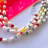 Collar corto de perlas de río blancas con cristales checos de colores y cierre de mosquetón plateado.