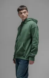 Hoodie oversize color verde, confeccionado en frisa premium con textura gamuzada. Presenta capucha ajustable con cordones personalizados, bolsillo frontal tipo canguro y puños con abertura para pulgar.