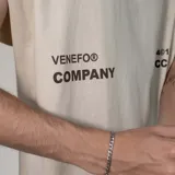 Musculosa de corte oversize color beige, con cuello redondo y sisas amplias. Presenta un estampado gráfico minimalista en color marrón en la parte frontal.