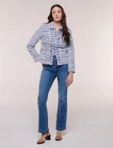 Chaqueta corta estructurada confeccionada en tejido texturado boucle estilo tweed en tonos azul, blanco y negro. Cuenta con forro interno, cuello camisero, frente abierto con bordes deshilachados, bolsillos tipo plaque al frente con botones metálicos y mangas largas.