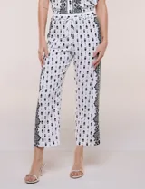 Pantalon crop de corte recto y calce fluido con textura liviana, color blanco con estampado a contraste, cintura elastizada y bolsillos laterales.