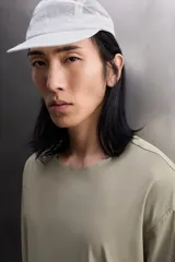 Camiseta de entrenamiento regular fit color gris oscuro, confeccionada en tejido técnico ligero y elástico con estructura. Cuenta con cuello redondo, manga larga y logo estampado en el bajo.