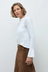 Remera de manga larga color terracota, con cuello alto y detalles de broderie en los hombros y puños acampanados.