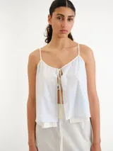 Blusa celeste claro con tirantes finos, escote en V y diseño abierto al frente con lazos para atar.