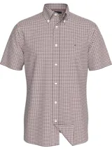 Camisa de manga corta Tommy Hilfiger con cuello abotonado y cierre frontal de botones. Presenta un diseño de cuadros gingham en tonos blanco y bordó, con el logo de la marca bordado en el pecho.