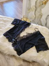 Top de encaje y lycra color negro, con escote profundo en V adornado con puntilla, mangas cortas de encaje y diseño con transparencias de microtul en los laterales y espalda.