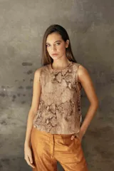 Musculosa de gabardina con estampado de piel de serpiente, cuello redondo y diseño estructurado con abertura en la espalda y ruedo irregular.
