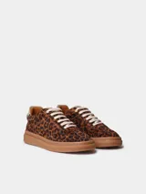 Zapatillas de cuero con estampado animal print tipo leopardo, cordones blancos y suela plana de goma.