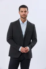 Saco sport de lana en color gris oscuro, con diseño clásico de solapa tradicional, cierre frontal de dos botones y bolsillos laterales con solapa.