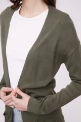 Saco tipo cárdigan abierto de tejido de punto, con mangas largas y bolsillos frontales aplicados.