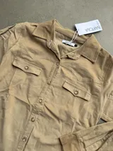 Chemise de pana elastizada color camel de la marca Bartola, con cuello camisero, cierre frontal de botones, bolsillos con solapa en el pecho y estilo western.