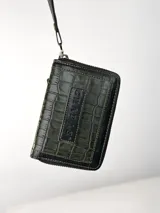 Mini billetera de cuero con textura efecto cocodrilo y cierre perimetral. Presenta un parche central con el logo de la marca grabado.
