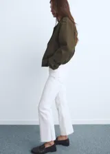 Jeans de tiro medio con diseño crop, estilo flare y bajo deshilachado, con cierre frontal de cremallera y botón, y cinco bolsillos.