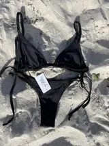 Bikini colaless negro con tiras finas ajustables en los laterales.