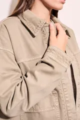 Sobrecamisa color beige de algodón con bordados en cuello, solapa, cierre y puños.